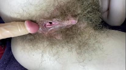 Ragazza pelosa si scopa la figa bagnata con un grande clitoride con un dildo da vicino